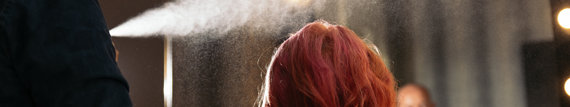laque appliquée sur les cheveux rose d'une femme